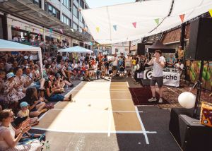 Ein junger Beatboxer steht mit Mikro in der Hand vor dem Publikum.